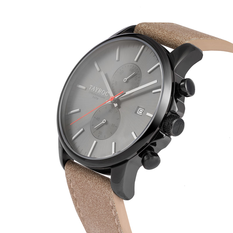 TXM093, a black chronograph watch from the Iconic Collection. A watch with black face and case, brought together with a leather strap. Side view.